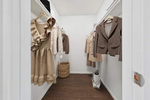 A hallway with a coat rack and a basket on the floor.