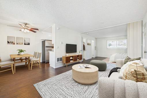 A living room with a wooden floor and furniture.