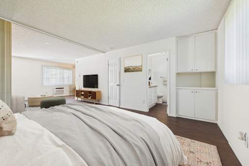 A bedroom with a large bed and a television in the corner.
