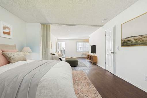 A bedroom with a large bed and a green chair.