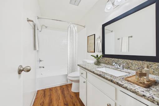 A bathroom with a toilet, sink, and shower.