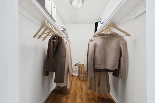 A hallway with two coats hanging on the wall.