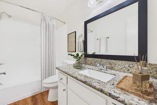 A bathroom with a marble countertop and a white toilet.