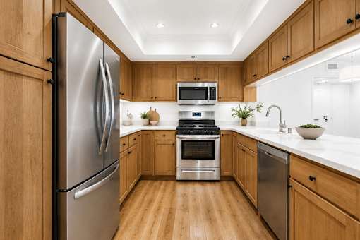 A modern kitchen with wooden cabinets and stainless steel appliances.