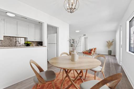 A modern dining room with a round wooden table and chairs.