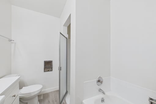 A white bathroom with a toilet, sink, and bathtub.