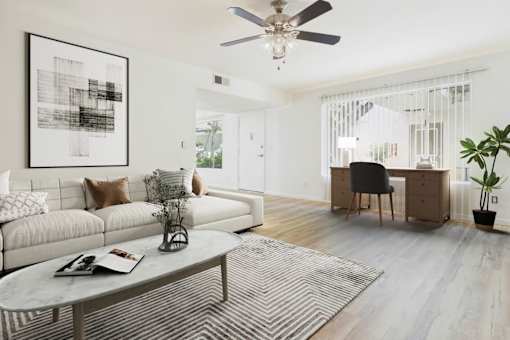 A living room with a white couch, a coffee table, and a ceiling fan.