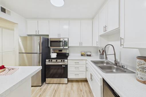 A kitchen with white cabinets and a black stove.