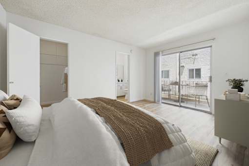 A bedroom with a large bed and a view of a balcony.