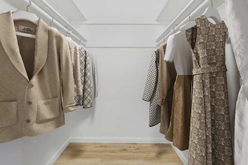 A row of coats and dresses hanging on a rack.