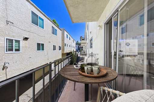 A balcony with a table and chairs overlooking a street.