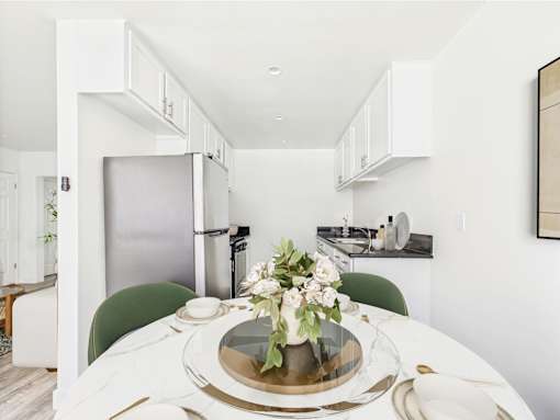 A modern kitchen with a table set for two.