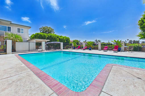 A swimming pool with a red border and a clear blue sky.
