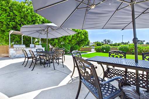 A patio with a table and chairs under an umbrella.