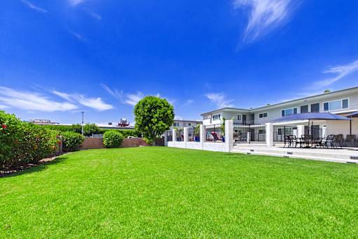 A large, well-maintained lawn in front of a modern house.