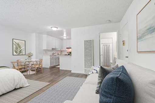 A living room with a grey couch and a dining table.