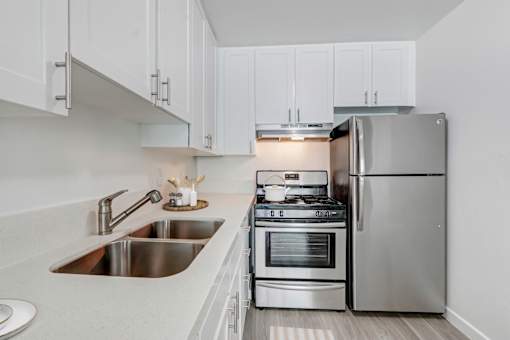 A modern kitchen with a stove, oven, and refrigerator.