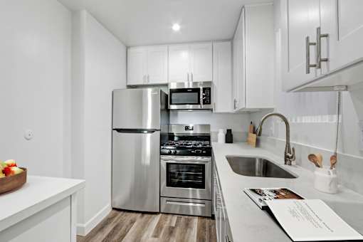 A modern kitchen with stainless steel appliances and white cabinetry.