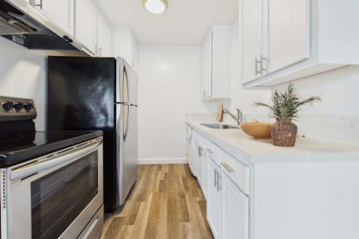 A kitchen with black appliances and white cabinets.