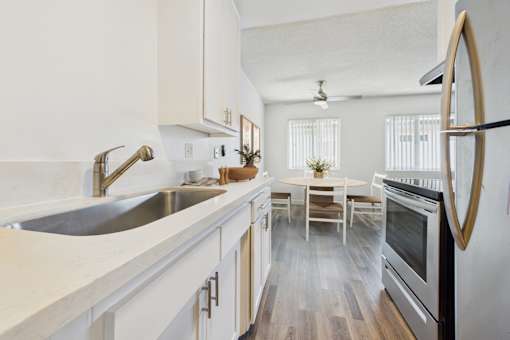A modern kitchen with a stainless steel oven and white cabinets.