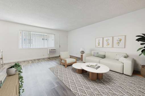 A living room with a white couch, a wooden coffee table, and a rug with a geometric pattern.