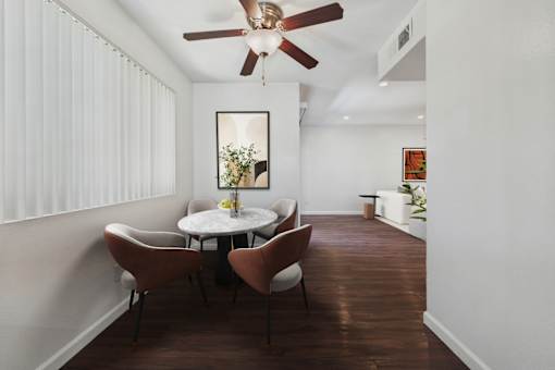 A dining room with a white table and chairs.