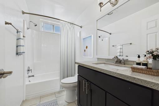 A bathroom with a white toilet, a sink, and a shower.
