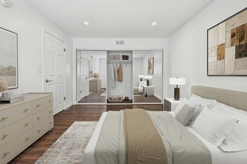 A bedroom with a large bed and a wardrobe in the background.