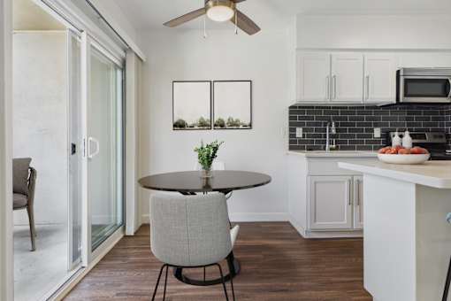 A modern kitchen with a dining table and chairs.