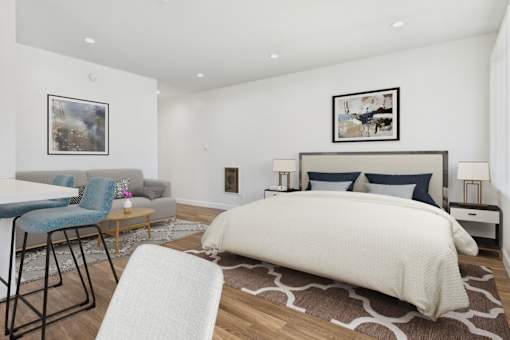 A bedroom with a large bed and a chair.