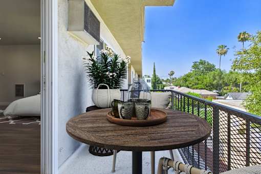 A table with a plant and two vases on it.
