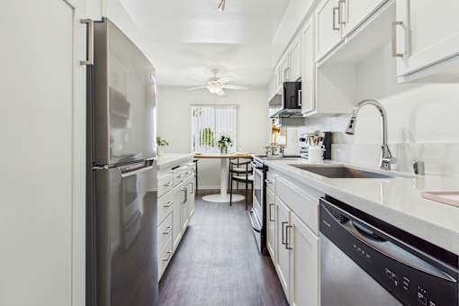 A modern kitchen with a refrigerator, sink, and stove.