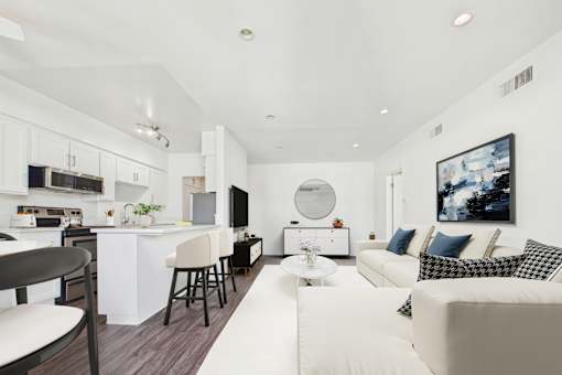 A modern kitchen with white cabinets and a bar area.