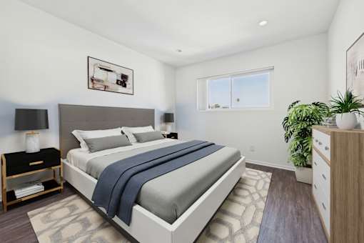 A bedroom with a large bed and a plant on the side table.