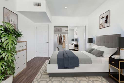 A bedroom with a large bed and a plant.