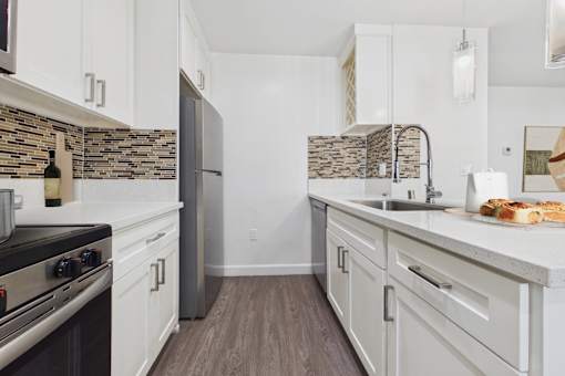 A kitchen with a black stove top oven and white cabinets.