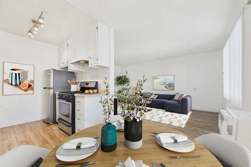 A modern kitchen with a dining table set for two.