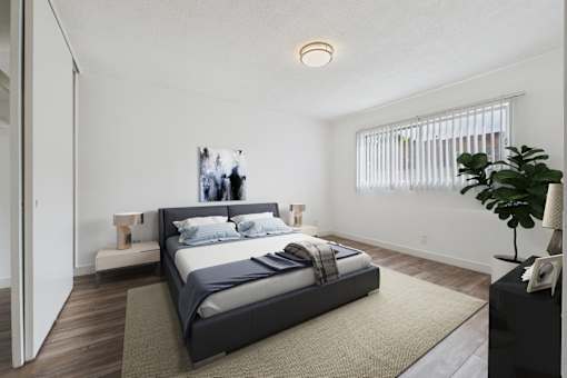 A bedroom with a large bed and a plant on the side table.