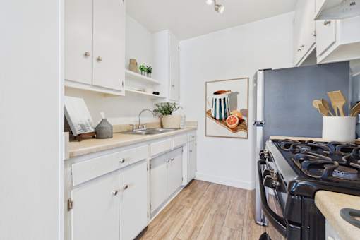 A kitchen with white cabinets and a black stove top oven.