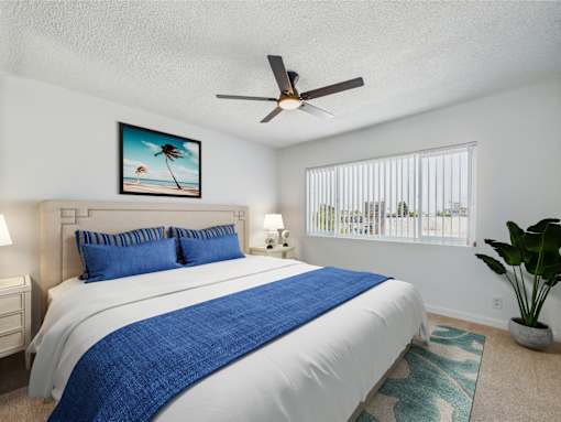 A bedroom with a large bed and a ceiling fan.