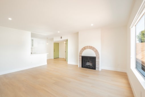 a living room with a fireplace and wooden floors