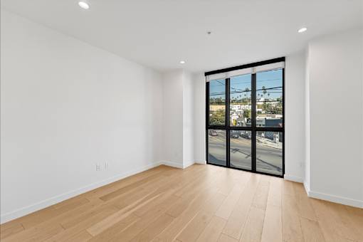 A room with a sliding glass door leading to a street.