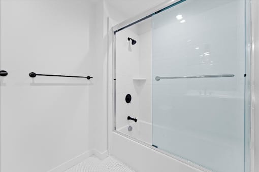 A white bathroom with a glass shower door.