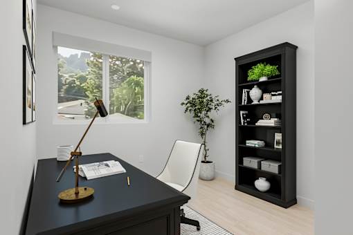 A black desk with a lamp and a chair in front of a window with a view of trees and houses outside.