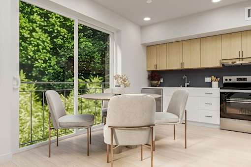 A modern kitchen with a table and chairs by a window.