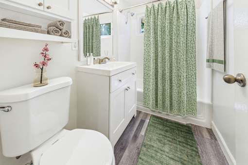 A white toilet sits next to a white cabinet in a bathroom.