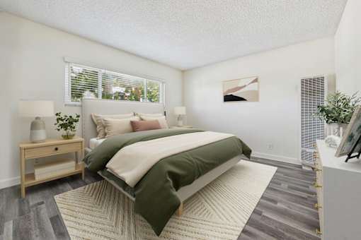 A bedroom with a large bed and a nightstand with a lamp.