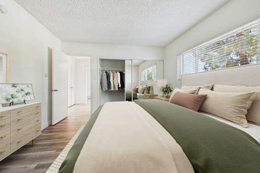 A bedroom with a large bed and a wardrobe.