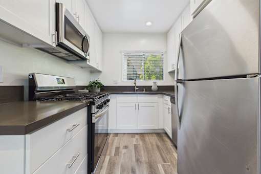 A modern kitchen with white cabinets and stainless steel appliances.