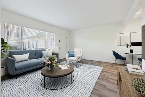 A living room with a blue couch, a coffee table, and a chair.